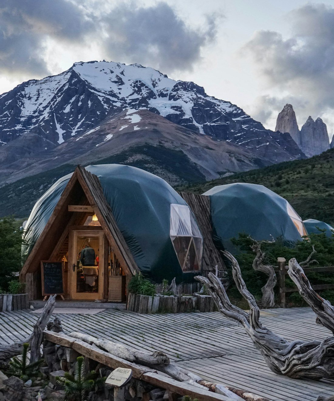 Geodesic glamping domes beneath snow-capped mountains